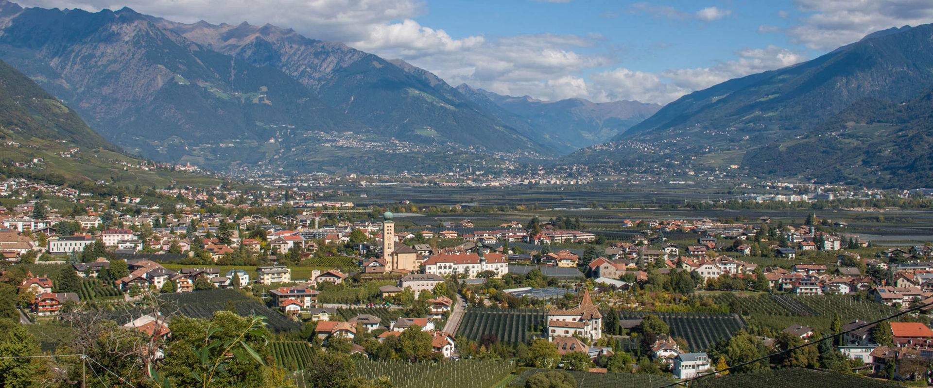 Lana presso Merano. Vista delle case, dei verdi vigneti e dei frutteti di Lana.