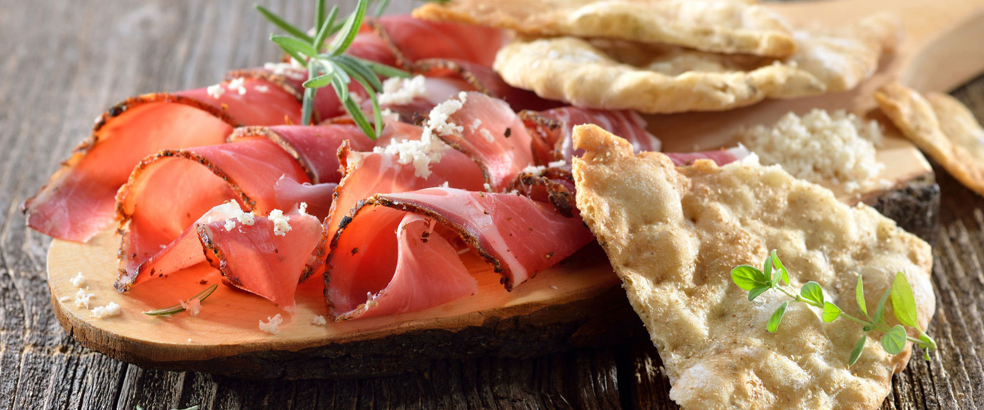 Schüttelbrot Tagliere in legno con speck, rafano e Schüttelbrot, un pane dell'Alto Adige.