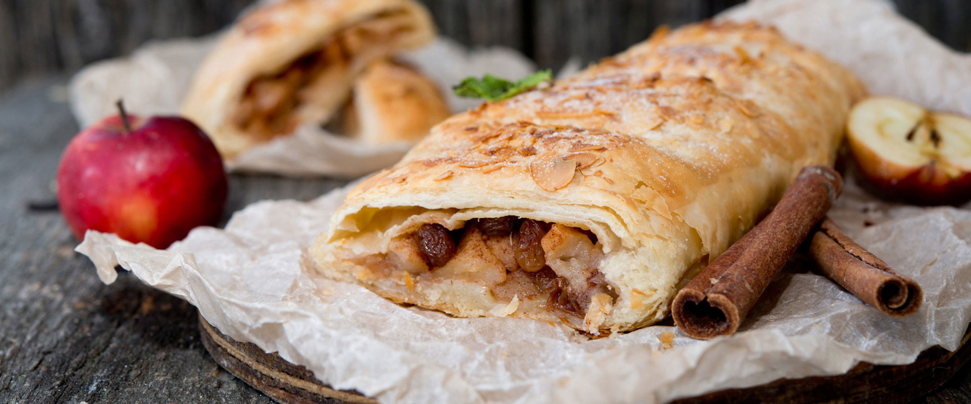 Strudel di mele Strudel di mele, decorato con bastoncini di cannella e mele.
