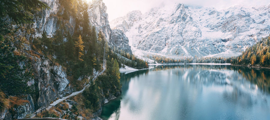 Natura in Alto Adige: Lago di montagna di colore blu intenso circondato da montagne e foreste innevate