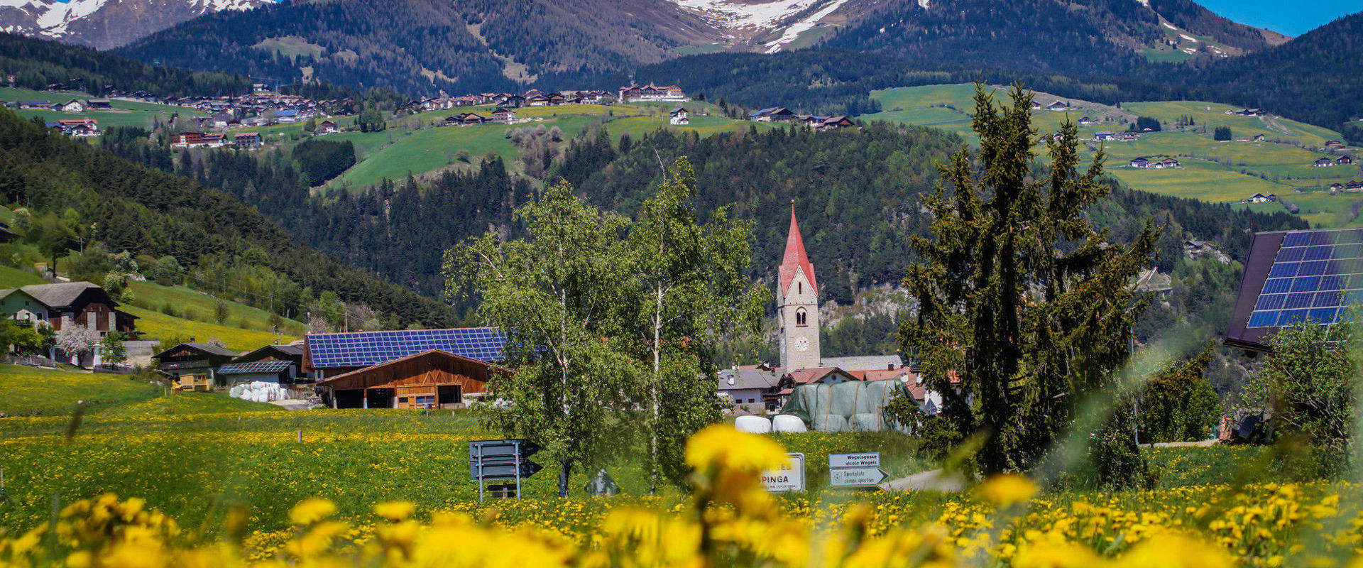Spinga Vista su Spinga e la sua chiesa in primavera con le montagne sullo sfondo