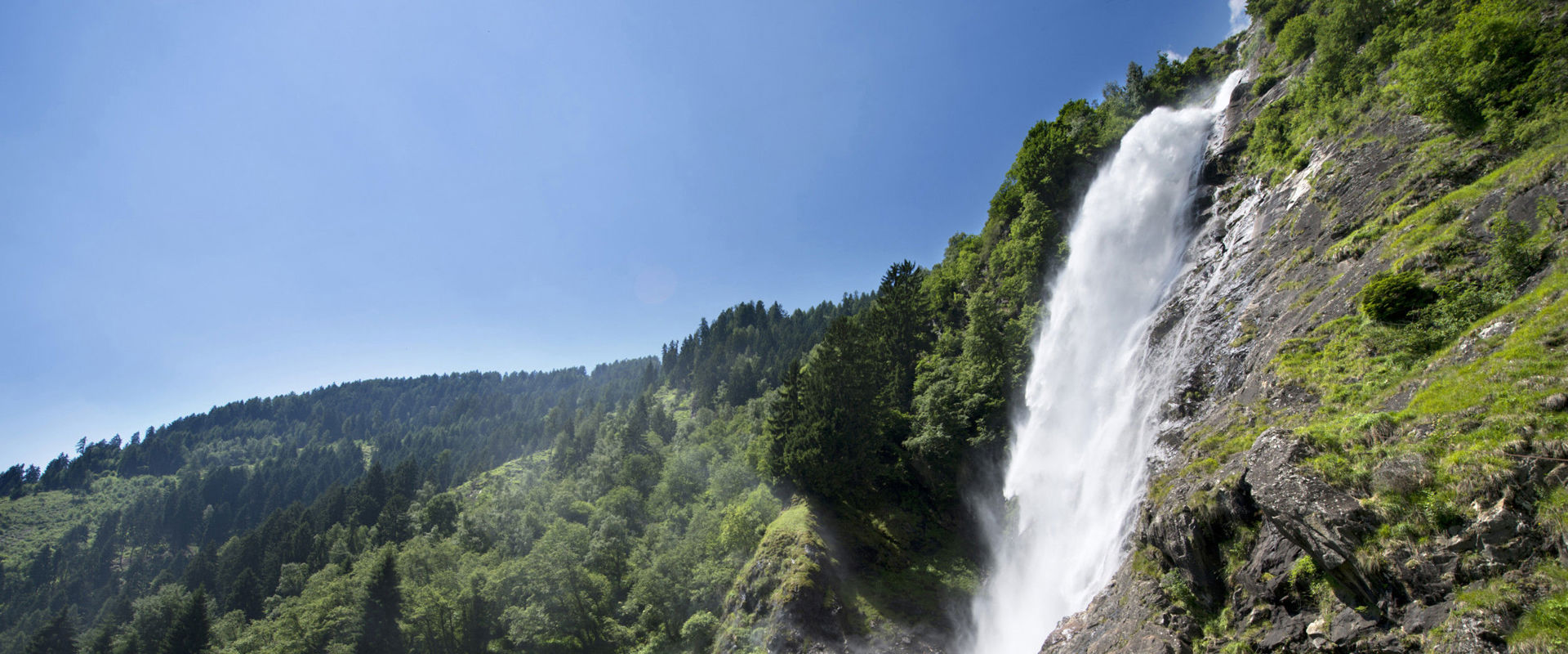Cascata di Parcines Cascata mozzafiato in mezzo a prati verdi e fitti boschi.