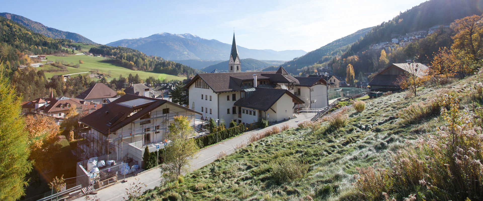 Rio di Pusteria nella Valle Isarco. Vista del villaggio e della guglia della chiesa in autunno.