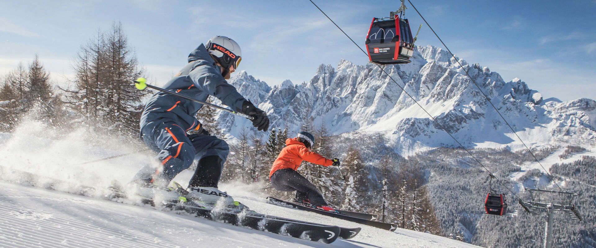 Sciare in Alta Pusteria. Due sciatori su una pista appena battuta sotto la cabinovia.