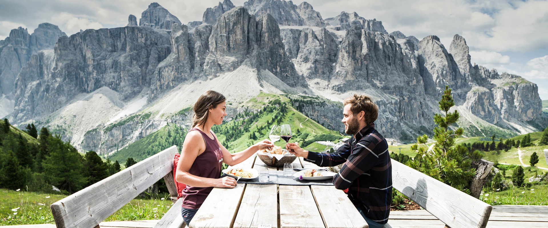 Coppia che brinda a tavola in un terrazza con vista sulle Dolomiti