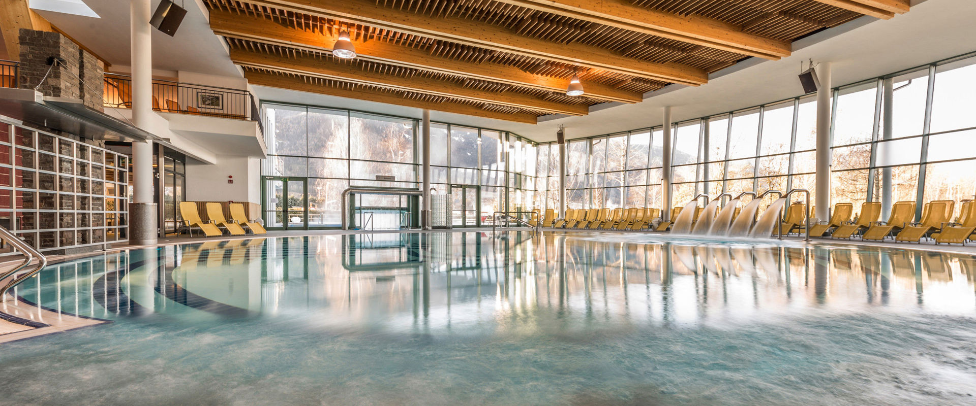Piscina coperta con lettini gialli.