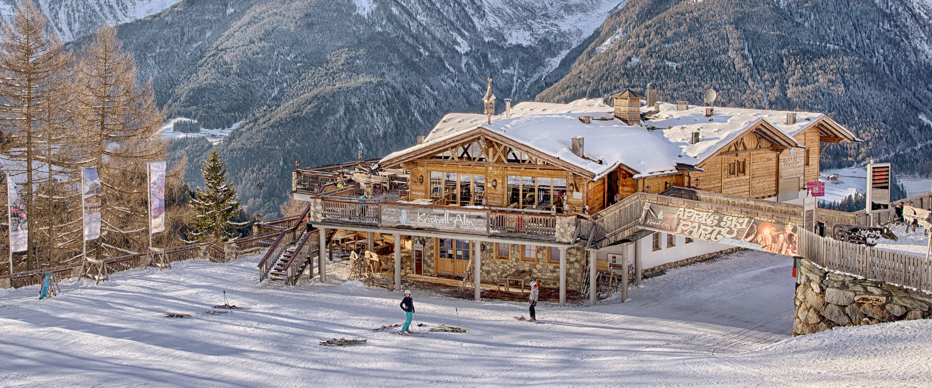 Kristallalm nel comprensorio sciistico di Klausberg Rifugio di montagna rivestito in legno sulla pista da sci e circondata da montagne innevate.