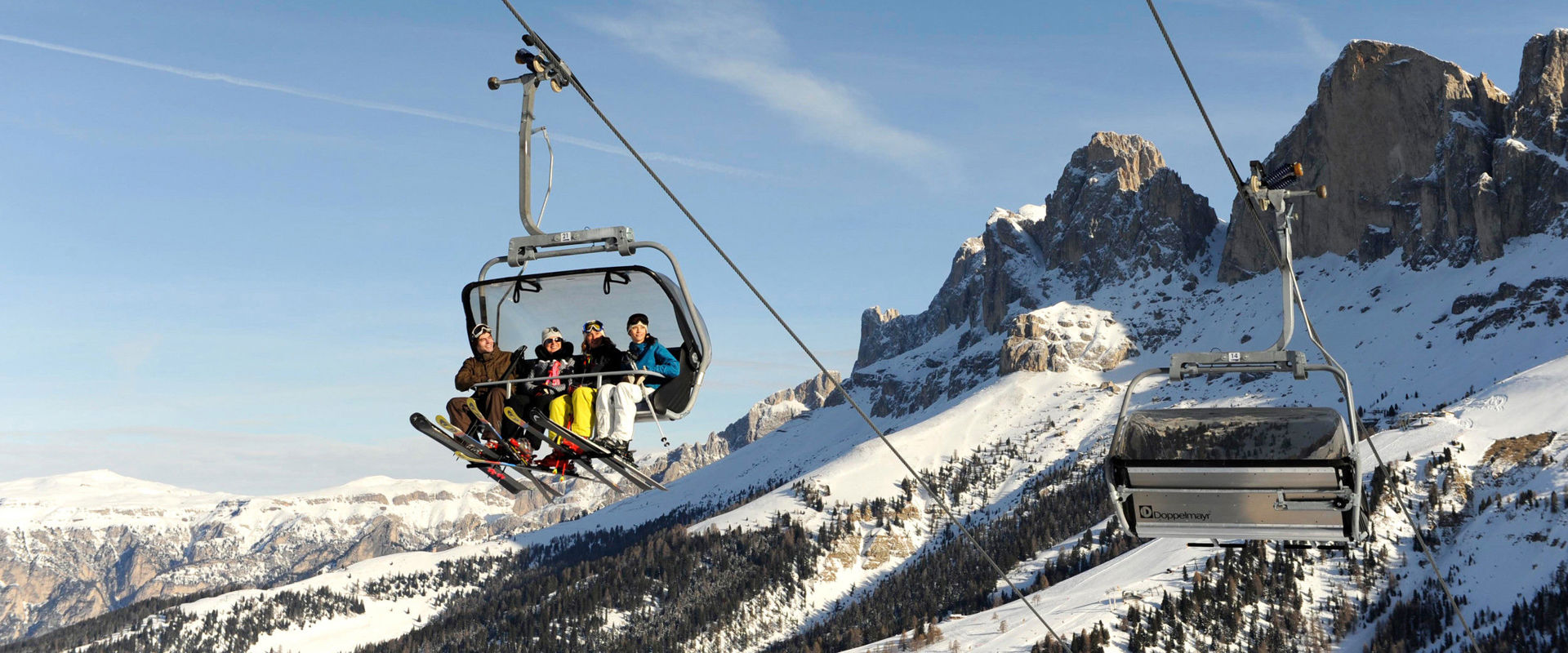 Sciatori seduti in seggiovia 4 sciatori seduti in seggiovia. Sullo sfondo si vedono le 3 Cime di Lavaredo.