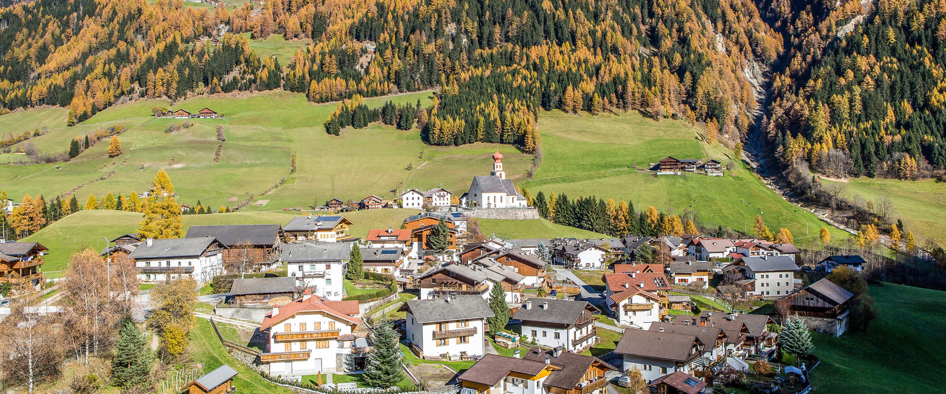 Fundres Fundres con chiesa parrocchiale & alberi dei colori dell'autunno