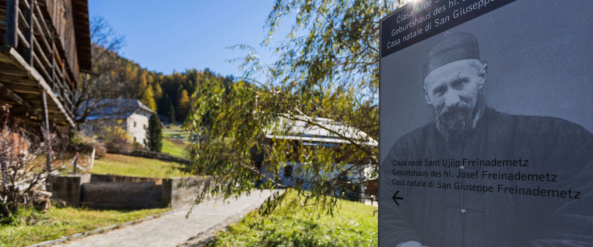 Tabellone informativo su S. Giuseppe Freinademetz con la sua casa natale a Oies