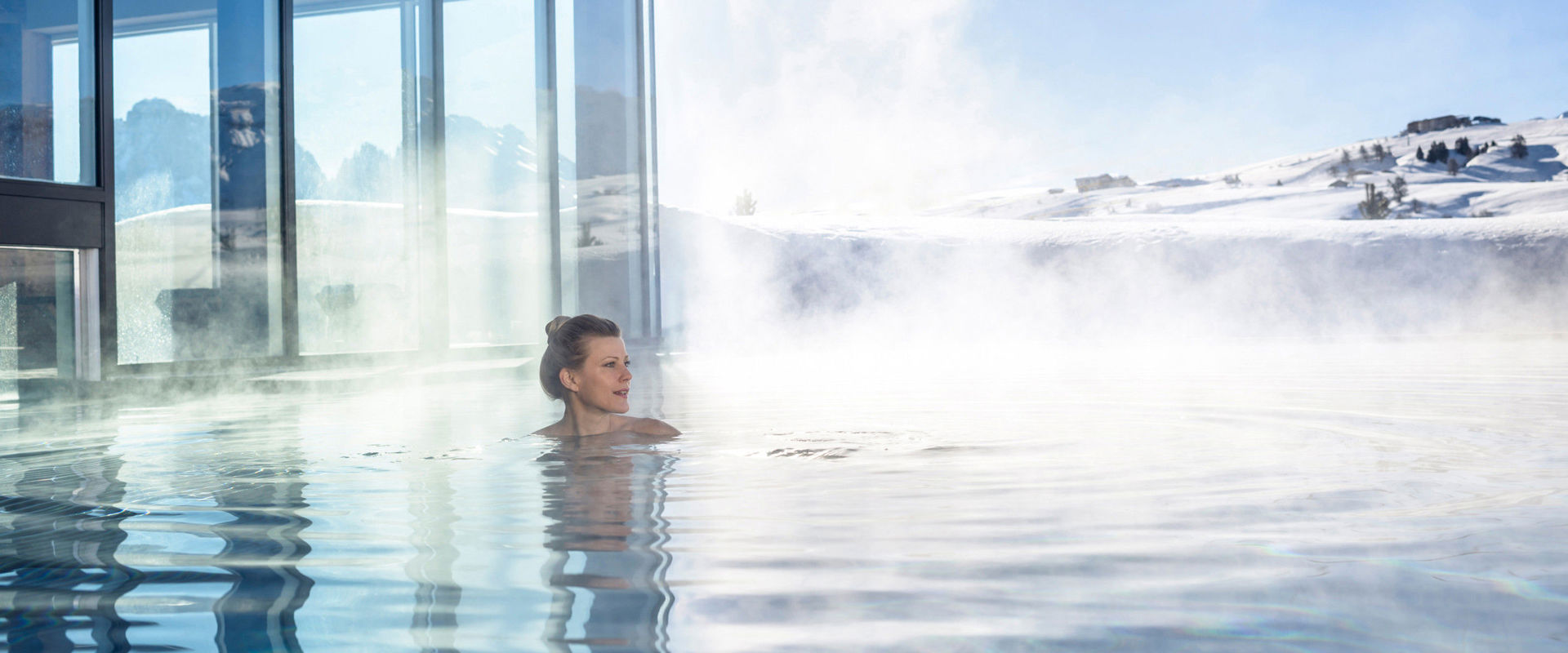 Piscina all'aperto Una donna nuota nella calda e fumante piscina all'aperto.