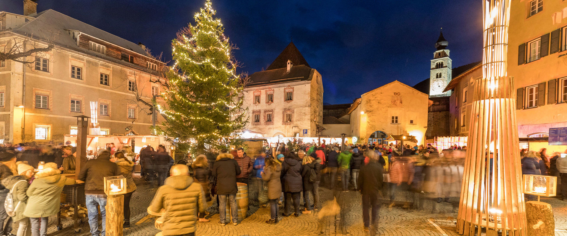 Piazza di Glorenza in un'atmosfera natalizia. Piazza di Glorenza affolata con albero di natale illuminato.