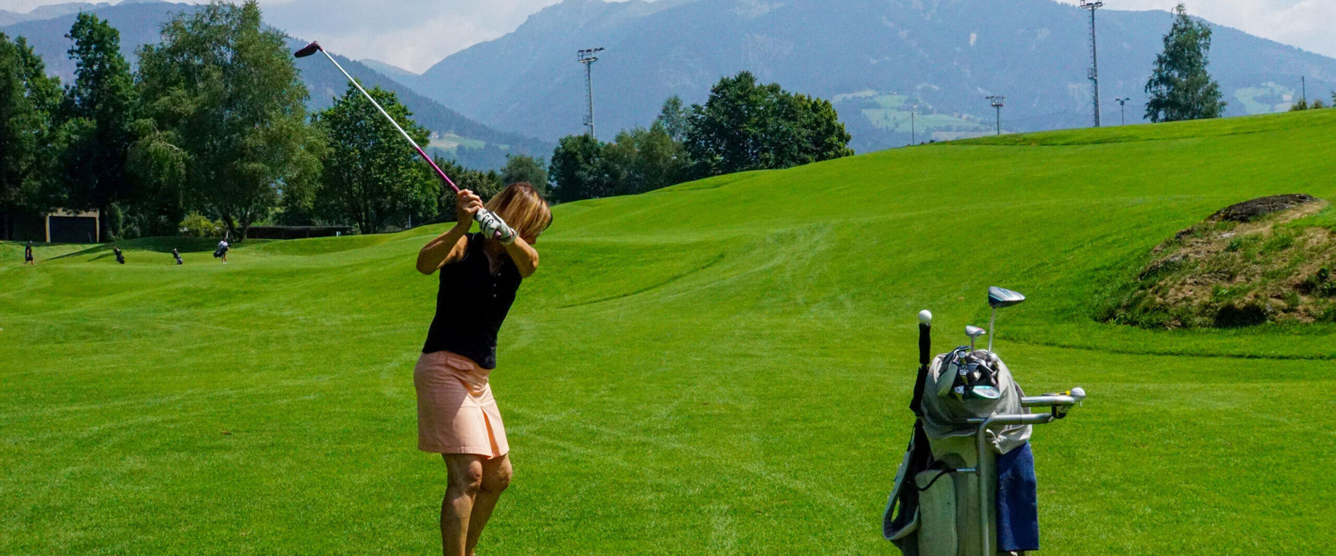 Donna al campo da golf Donna in piedi sul campo da golf pronta a tirare.