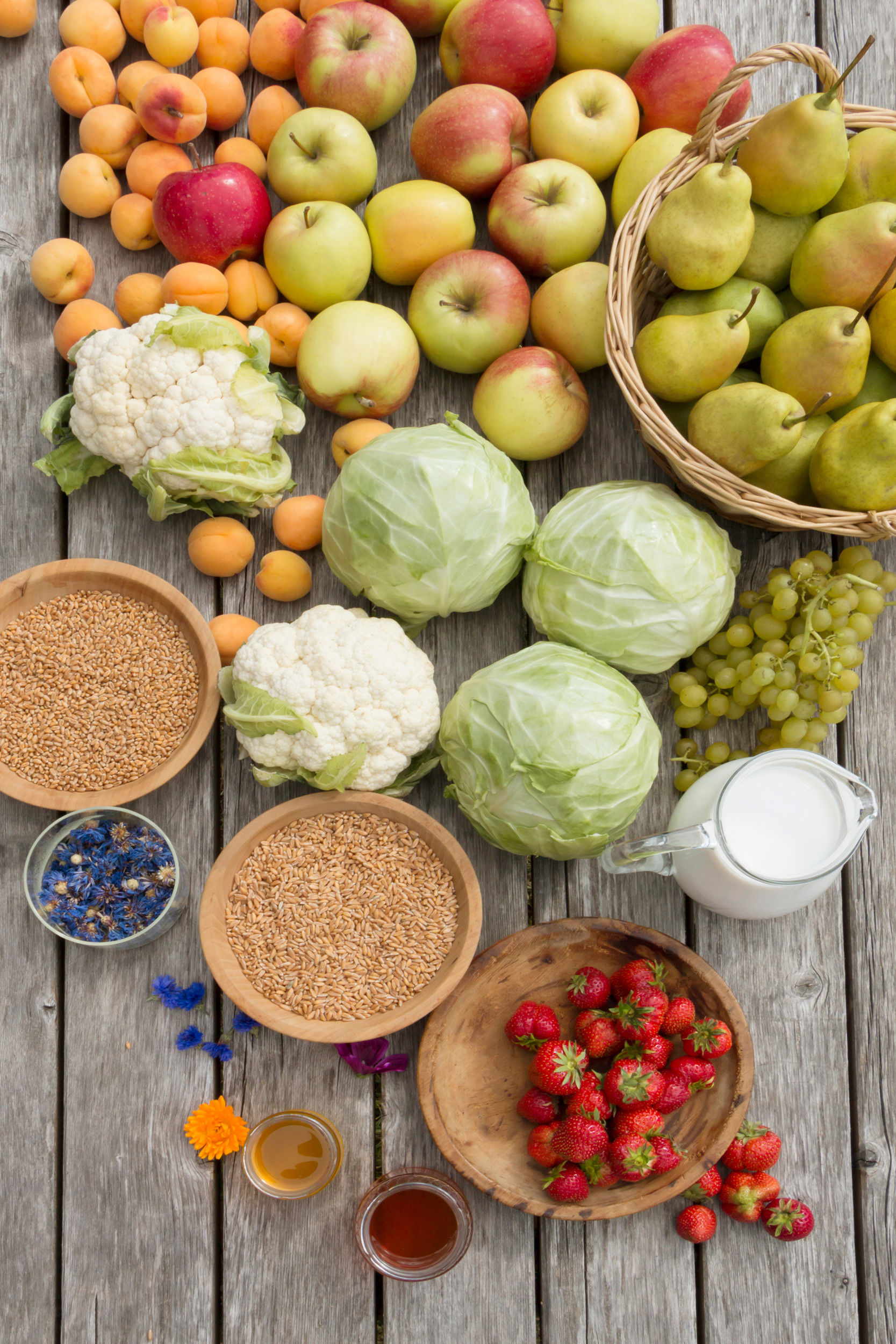 Tavola piena di frutta, verdura, latte, miele e cereali.