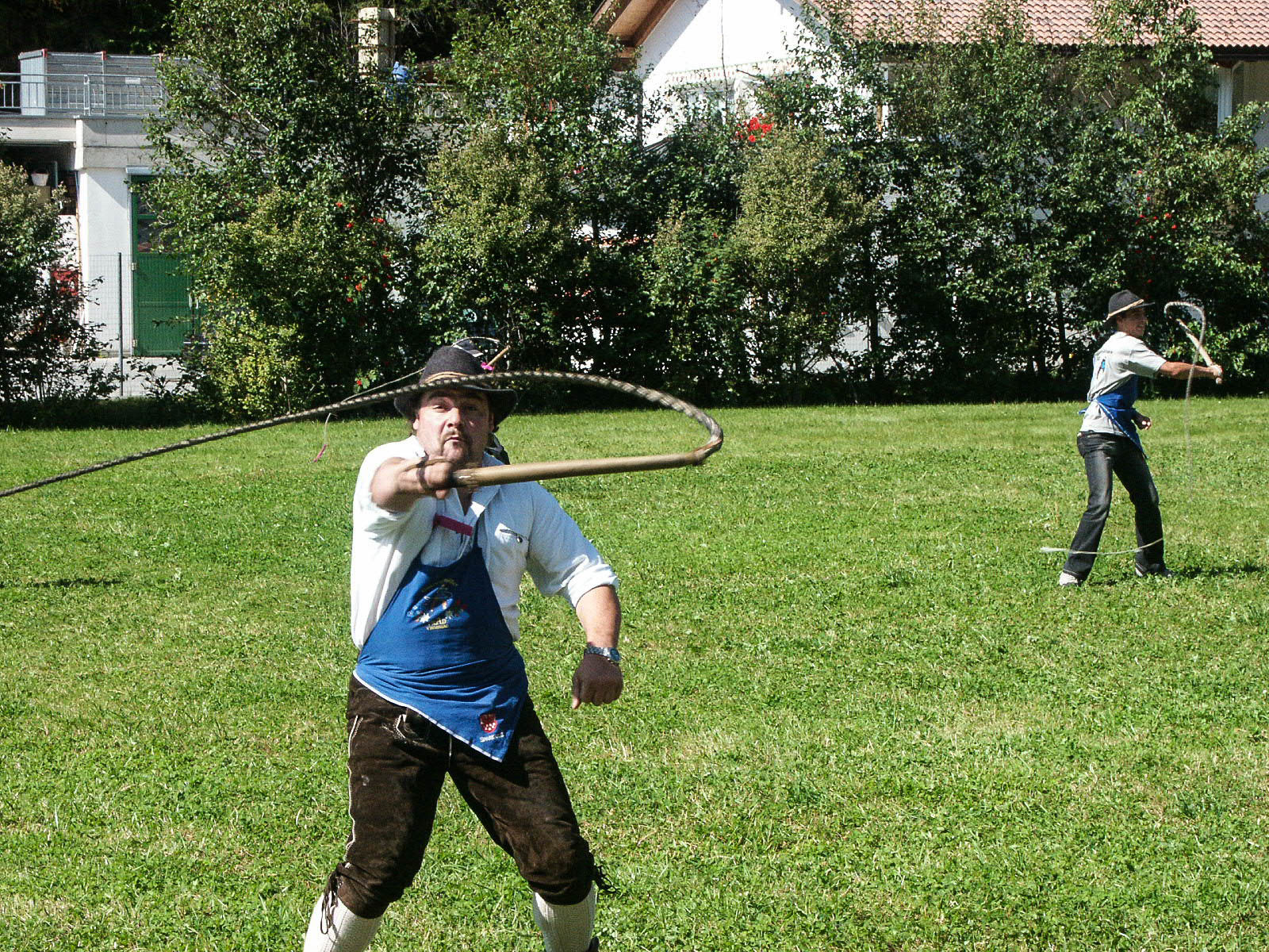 Uomo in abiti tradizionali tiene in mano una frusta.