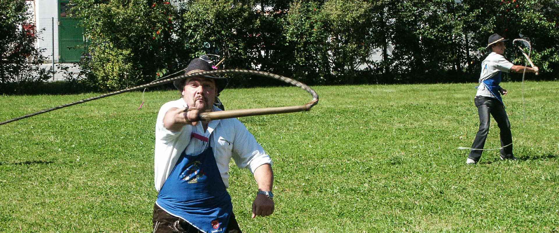 Goaslschnöllen Uomo in abiti tradizionali tiene in mano una frusta.