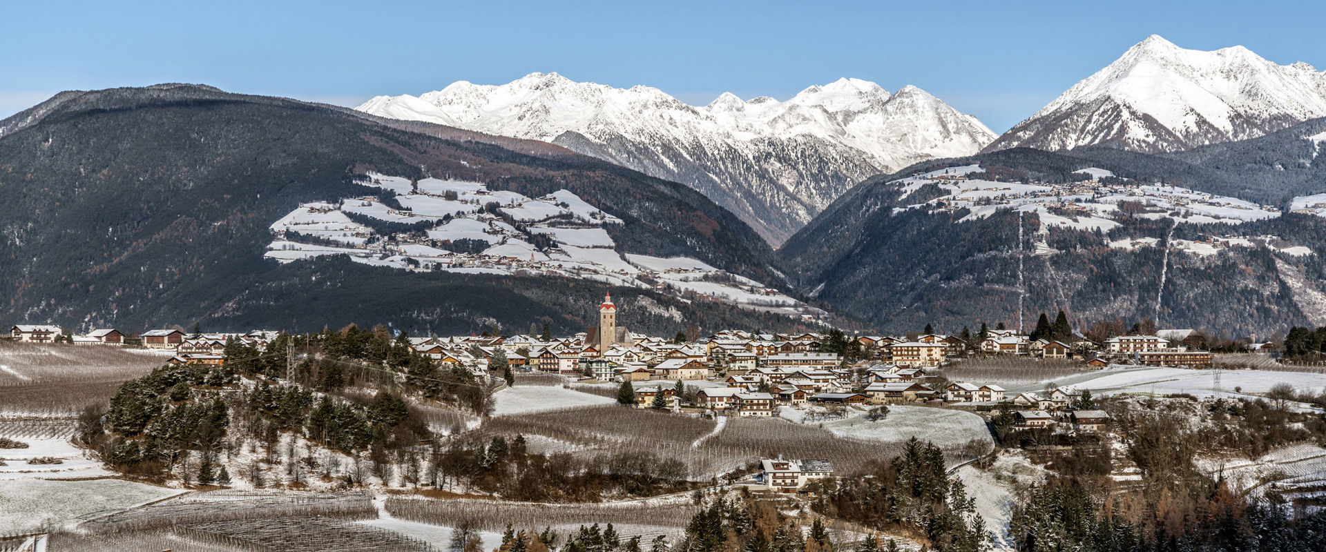 Naz Vista su Naz con la chiesa parrocchiale e le montagne di Fundres in inverno