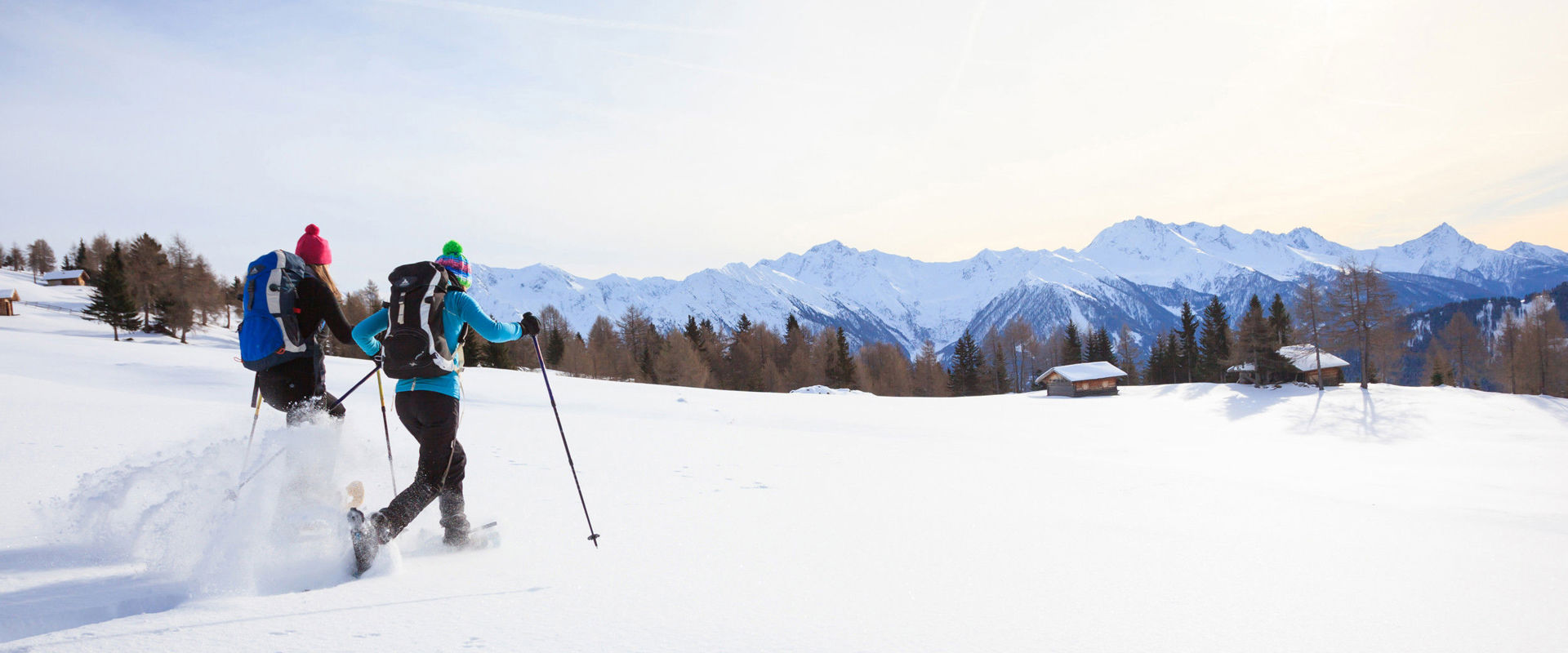 Due escursionisti con le racchette da neve in un paesaggio montano invernale.