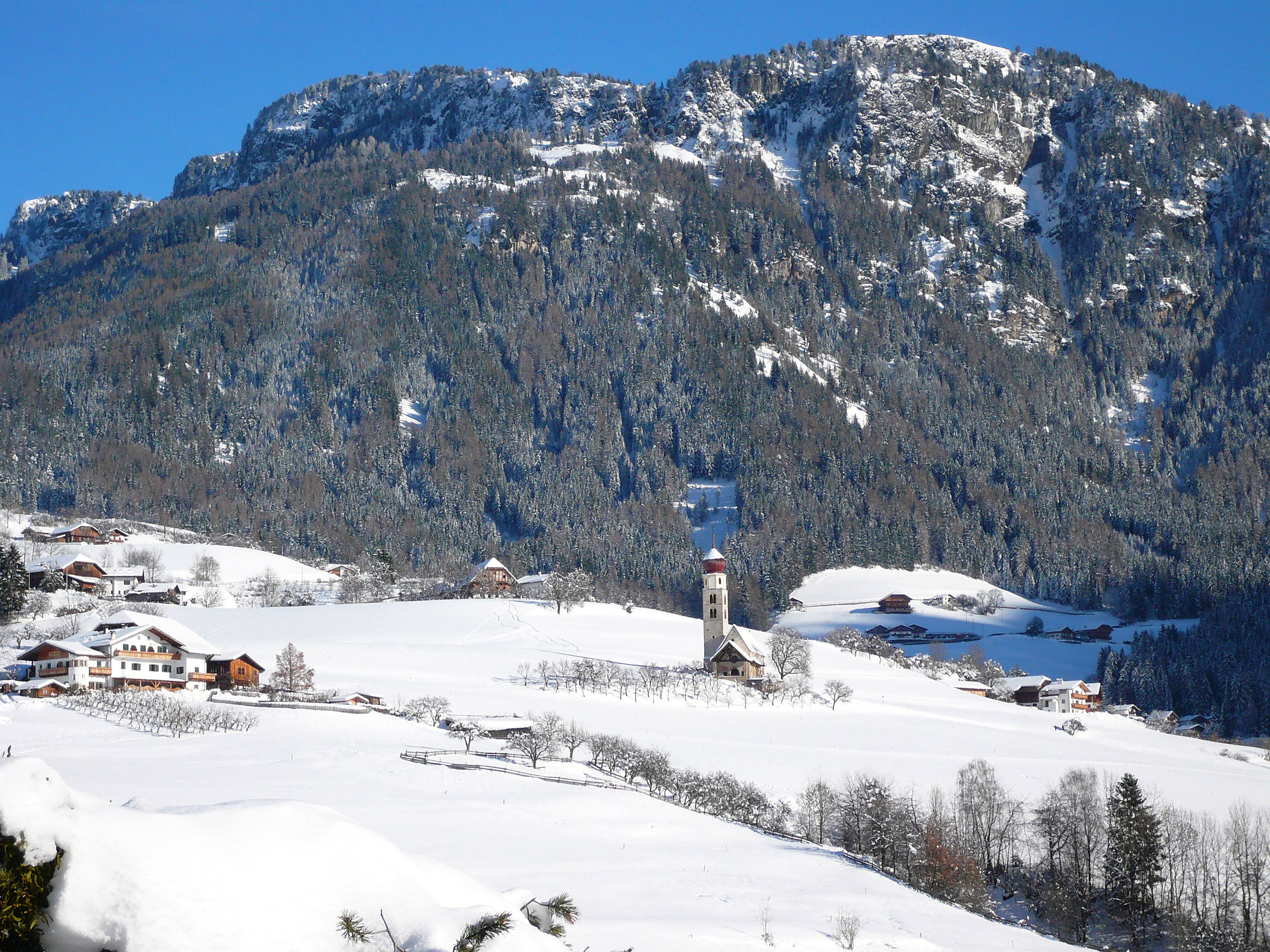 La chiesa di San Valentino giace solitaria nel paesaggio coperto di neve fresca.