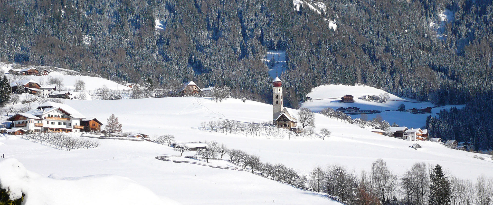 Chiesa di San Valentino e fattorie circostanti La chiesa di San Valentino giace solitaria nel paesaggio coperto di neve fresca.