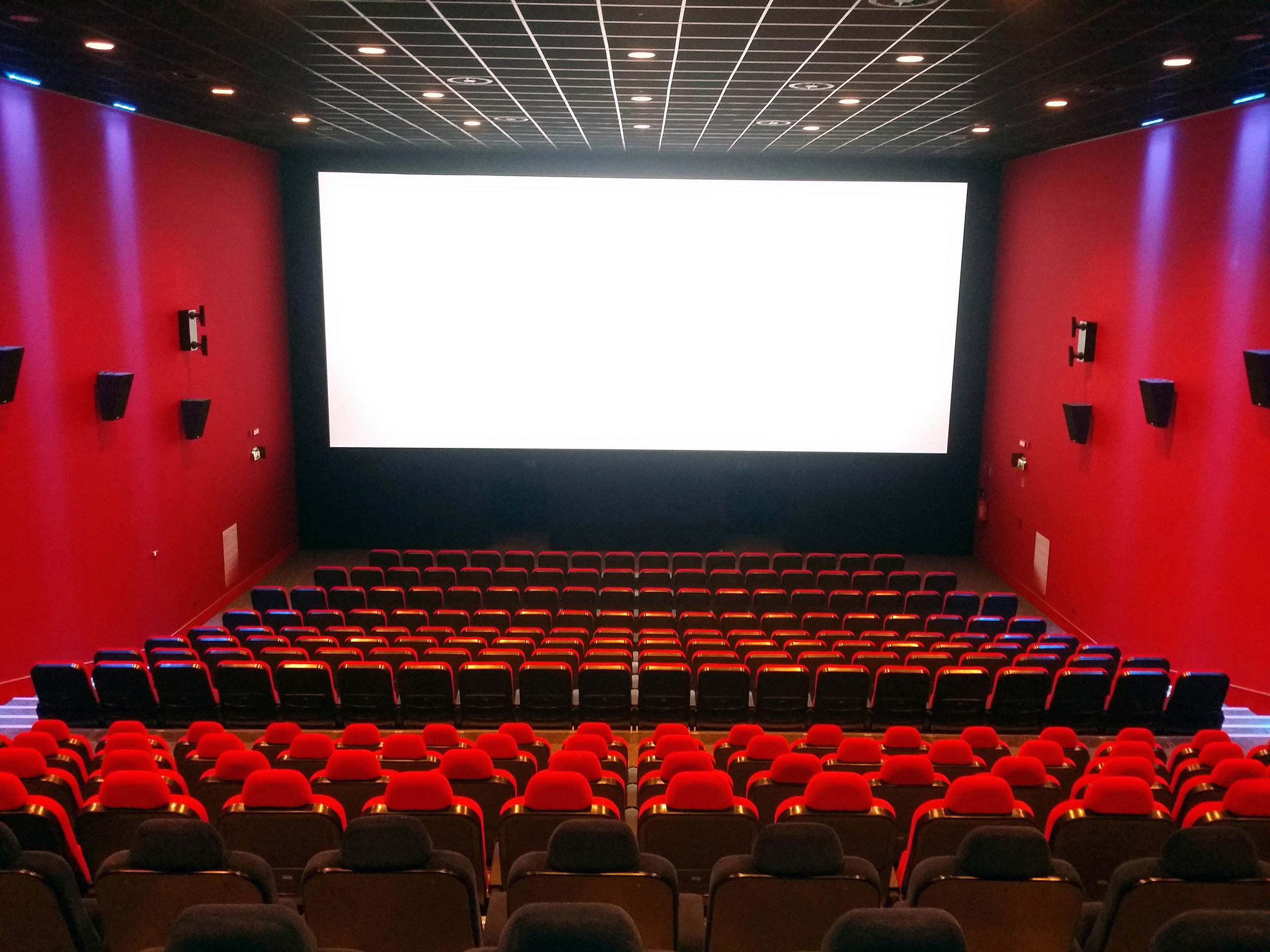 Sala cinematografica vuota illuminata di rosso.