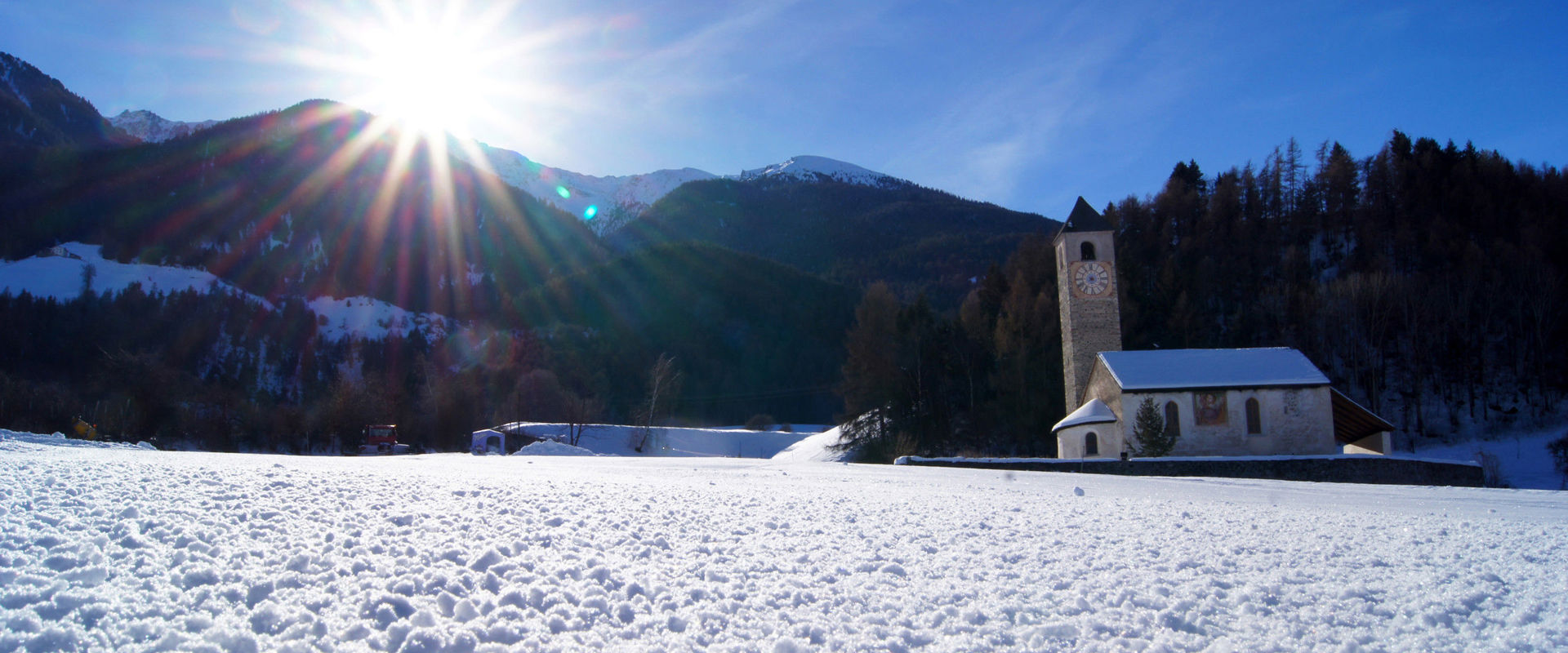 Lichtenberg a Prato allo Stelvio. Paesaggio innevato con chiesa.