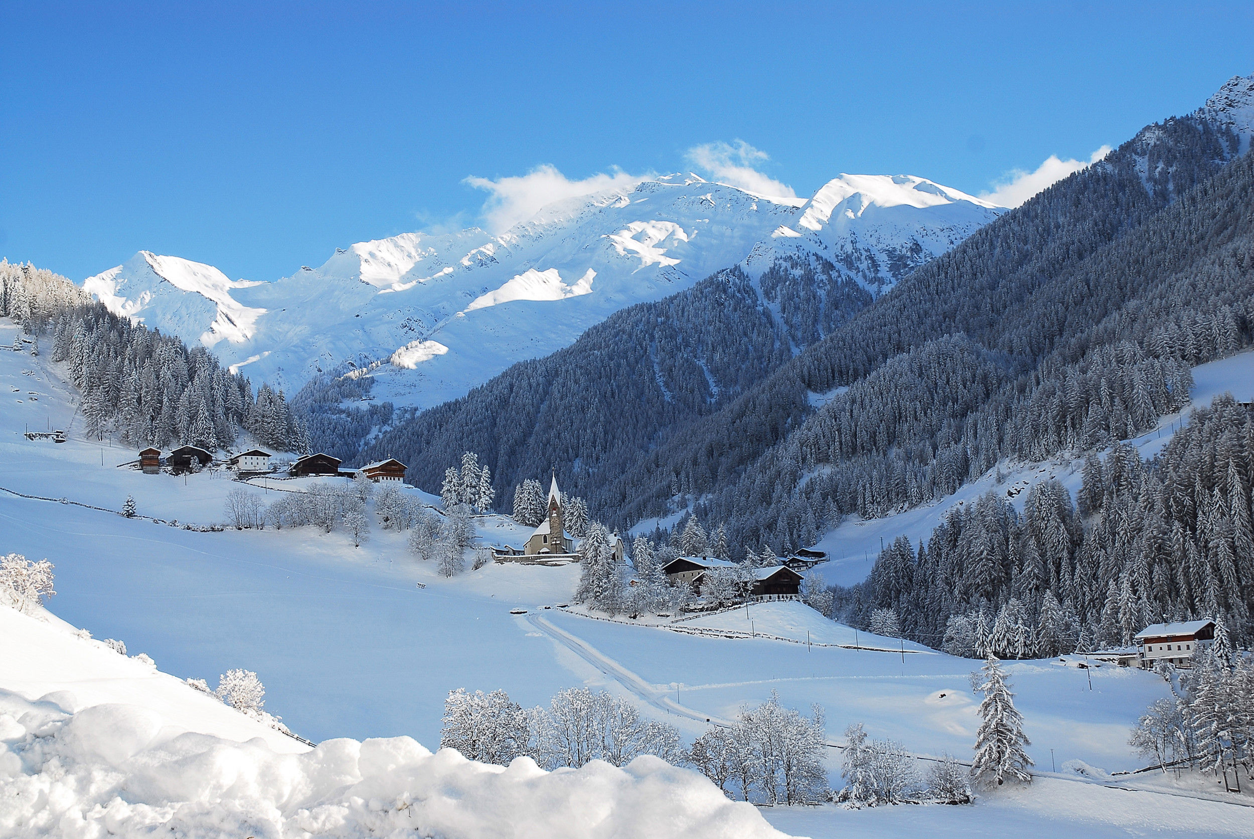 Vista di alcune case a San Pietro nella Valle Aurina con il paesaggio innevato circostante