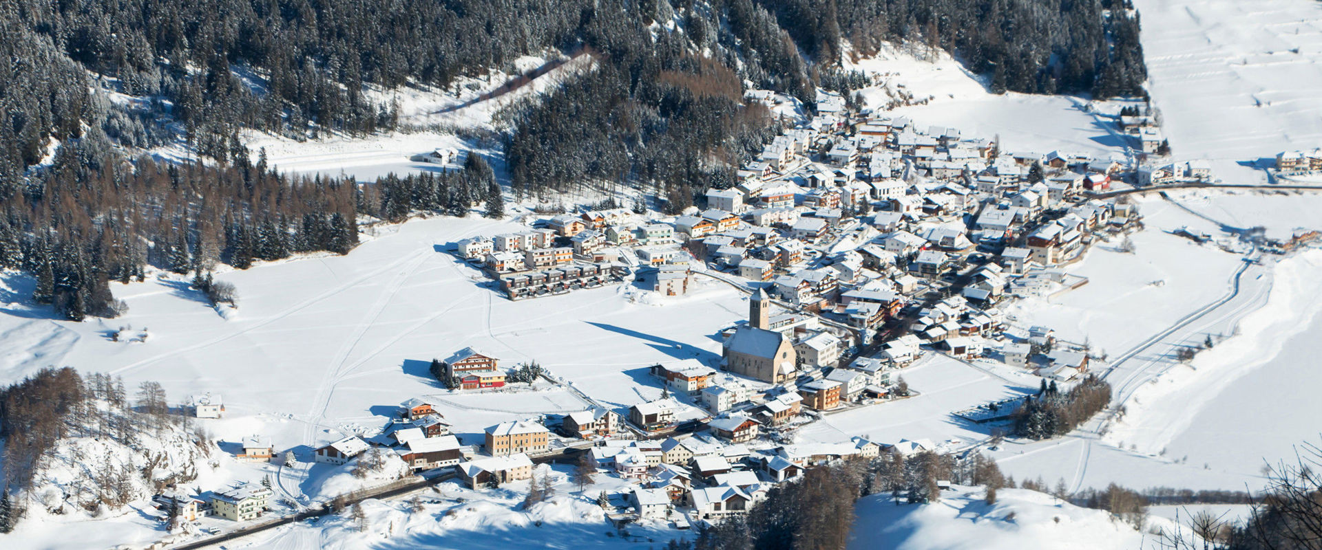 Resia in un'atmosfera invernale. Il villaggio di Resia visto dall'alto e coperto di neve.