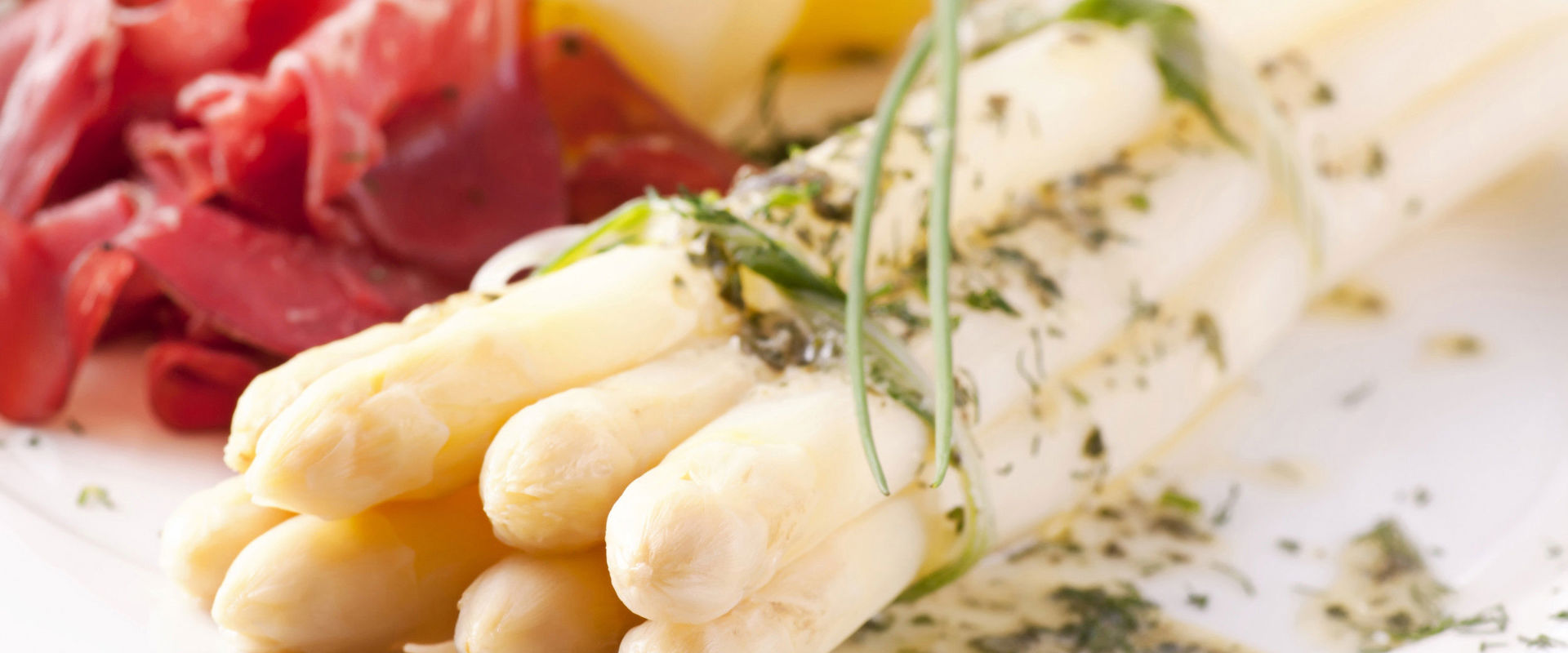 Piatto di asparagi con patate e affettato.