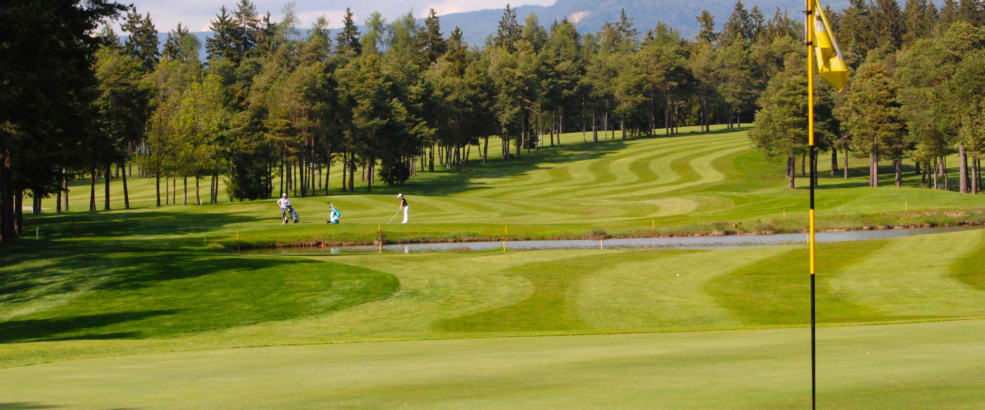 Golfclub Dolomiti Campo da golf con 2 golfisti.