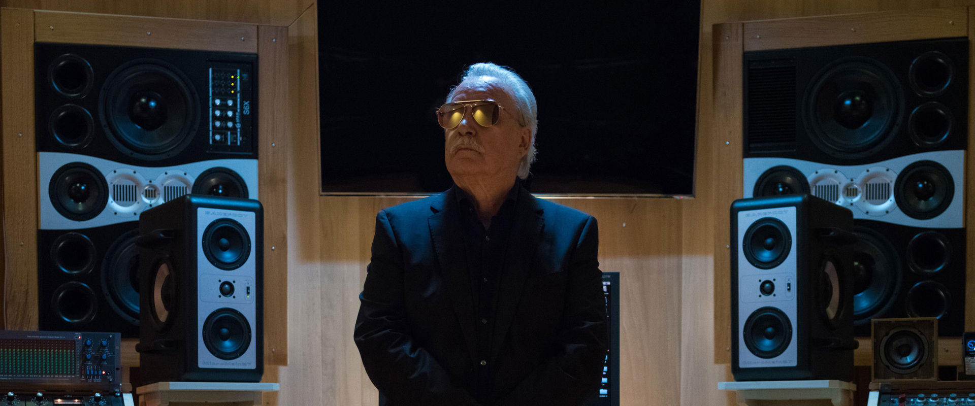 Giorgio Moroder Un anziano produttore musicale siede su una console di uno studio di registrazione.