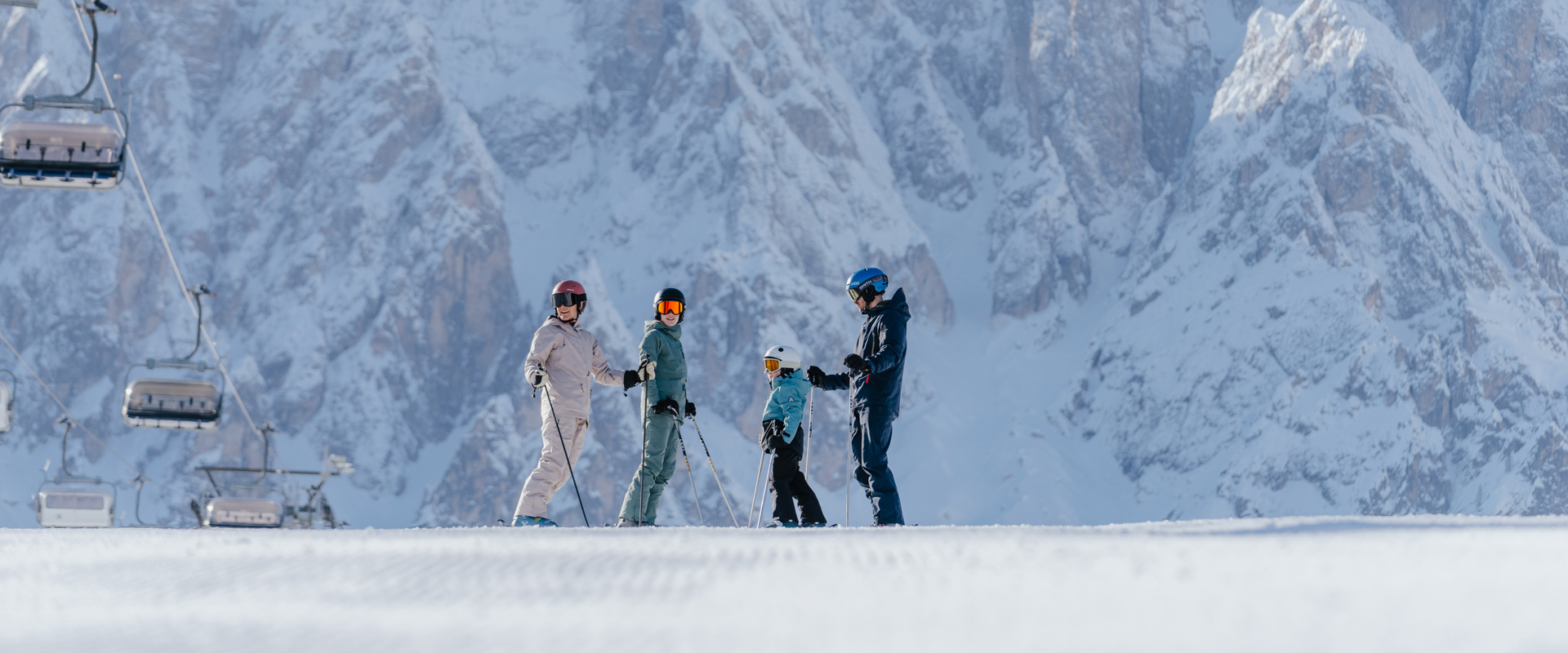 Sciare nelle Dolomiti Famiglia di sciatori in piedi sulla pista accanto a impianto di risalita