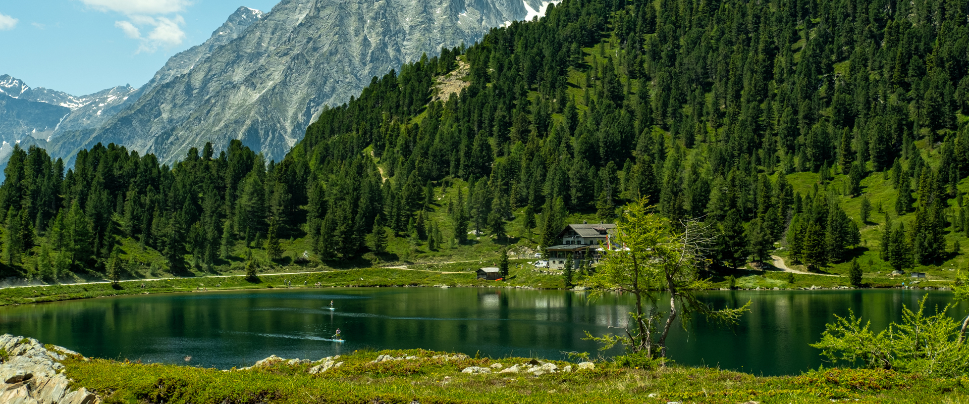 Lago Obersee Lago di montagna davanti a una baita, bosco e cime di montagna sul Passo Stalle