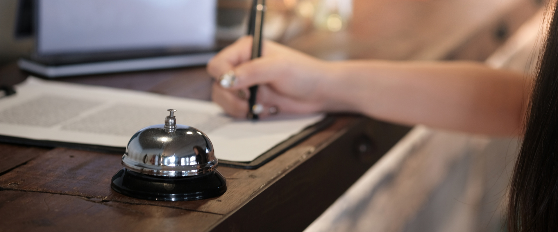 Imposta locale Campanello e persona che fa una firma alla reception dell'hotel