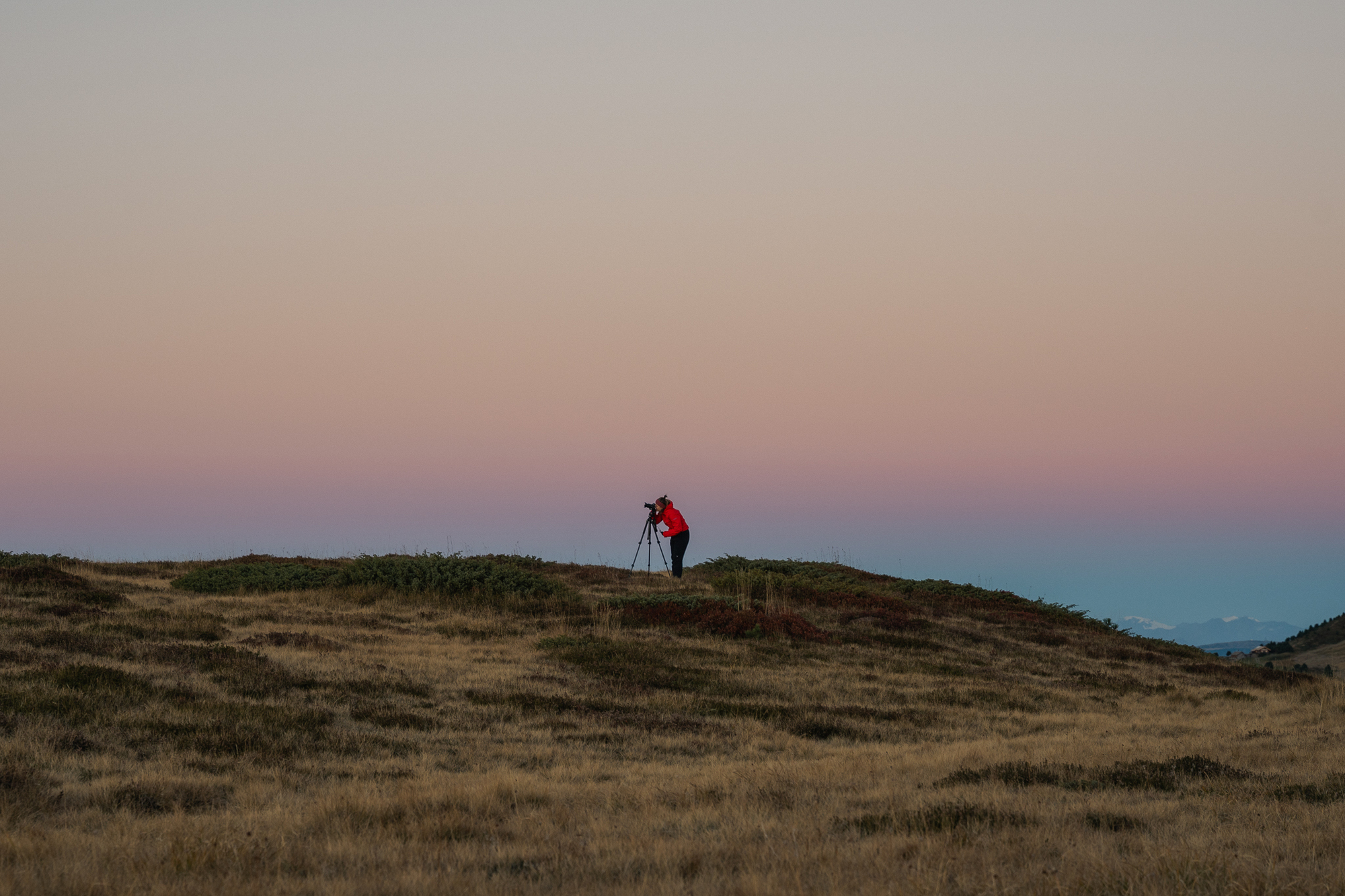 Fotografo al crepuscolo e al tramonto su un prato di montagna