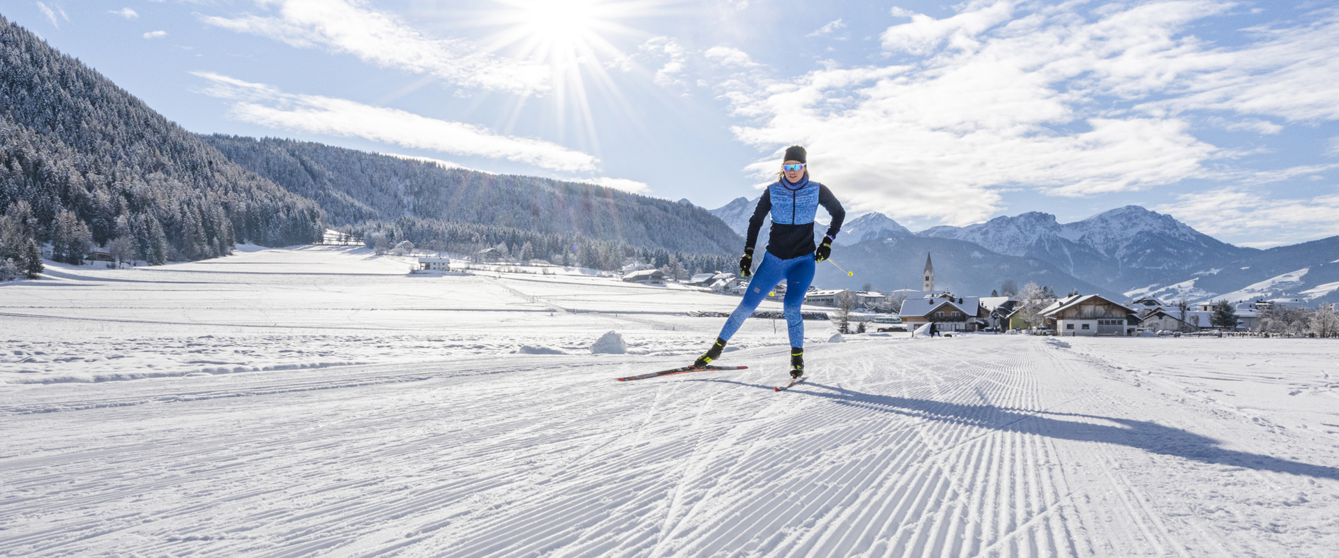 Sciatrice di fondo mentre pratica sport sulla pista da sci di fondo in una splendida giornata invernale
