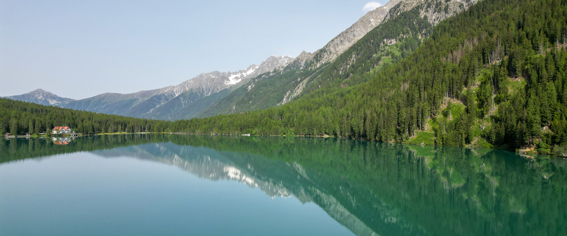 Lago di montagna (Lago di Anterselva) circondato da una foresta