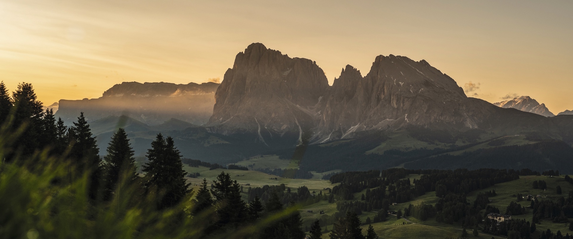 Il paesaggio verde e dolcemente ondulato dell'Alpe di Siusi, con il massiccio montuoso al centro