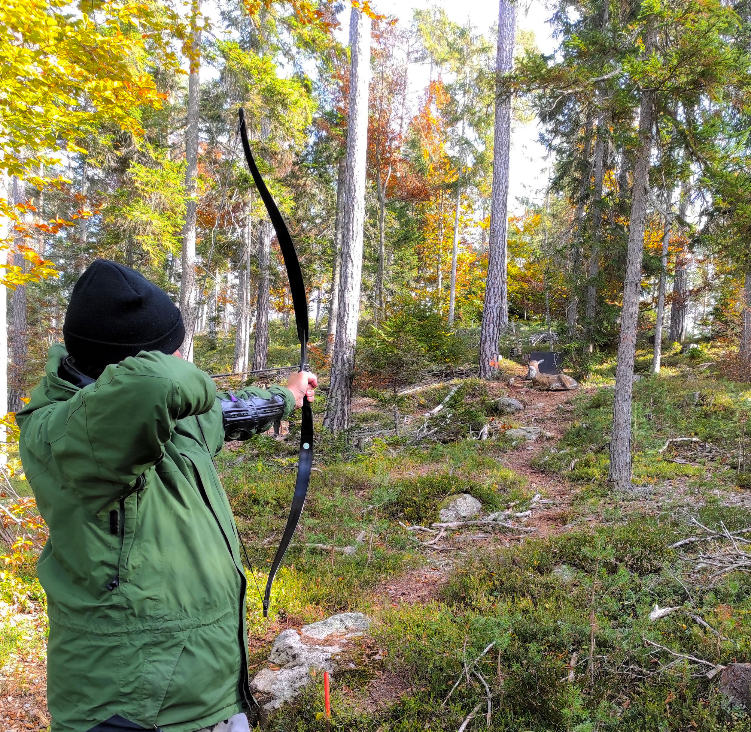 Un uomo prendere la mira per colpire un bersaglio in legno nel parco di tiro con l'arco a Renon.