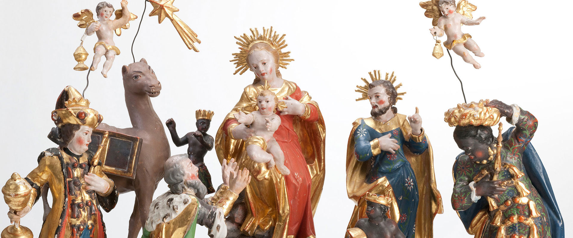 Figure scolpite di un presepe. Al centro Maria e Giuseppe con Gesù bambino.