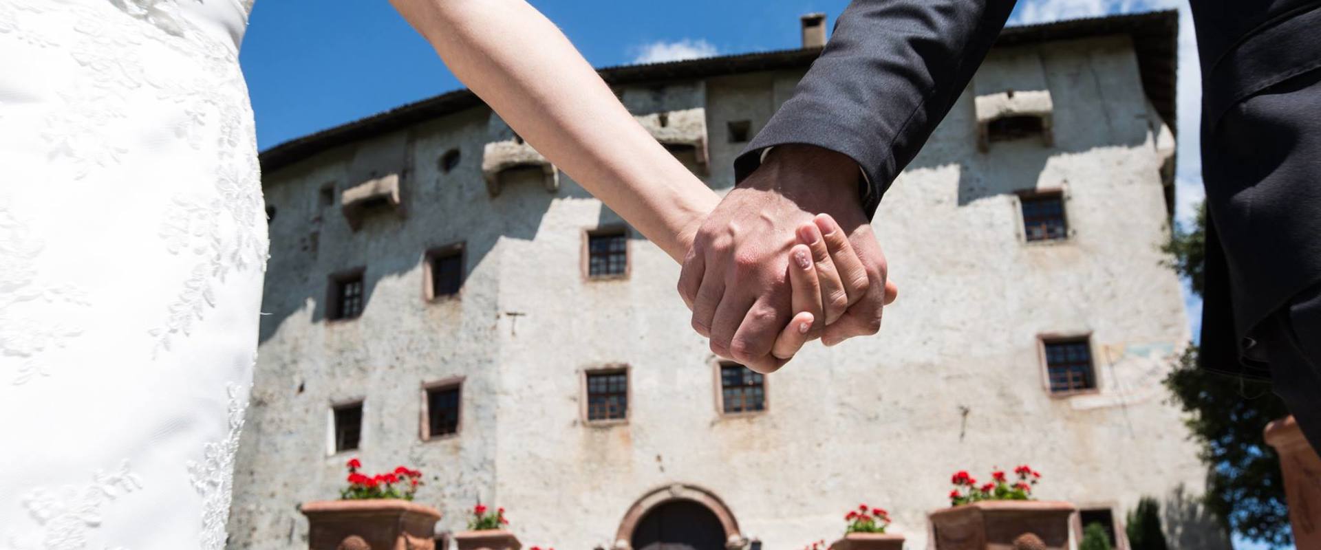 Gli sposi mano nella mano davanti a Castel Katzenzungen