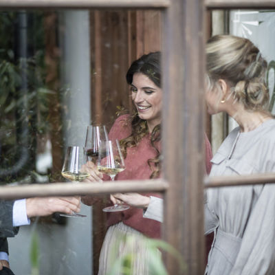 Tre amici bevono un bicchiere di vino bianco vicino alla finestra di un bar.