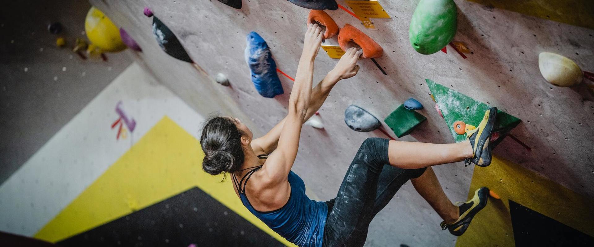 Ragazza arrampica in una palestra di arrampicata in Alto Adige