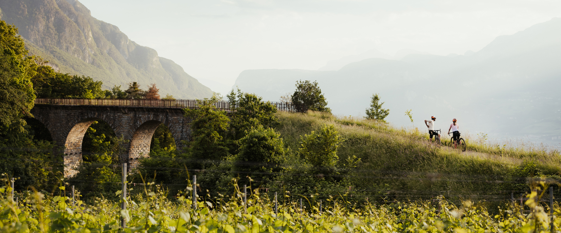 Ciclisti poco prima un ponte storico in mezzo alla campagna